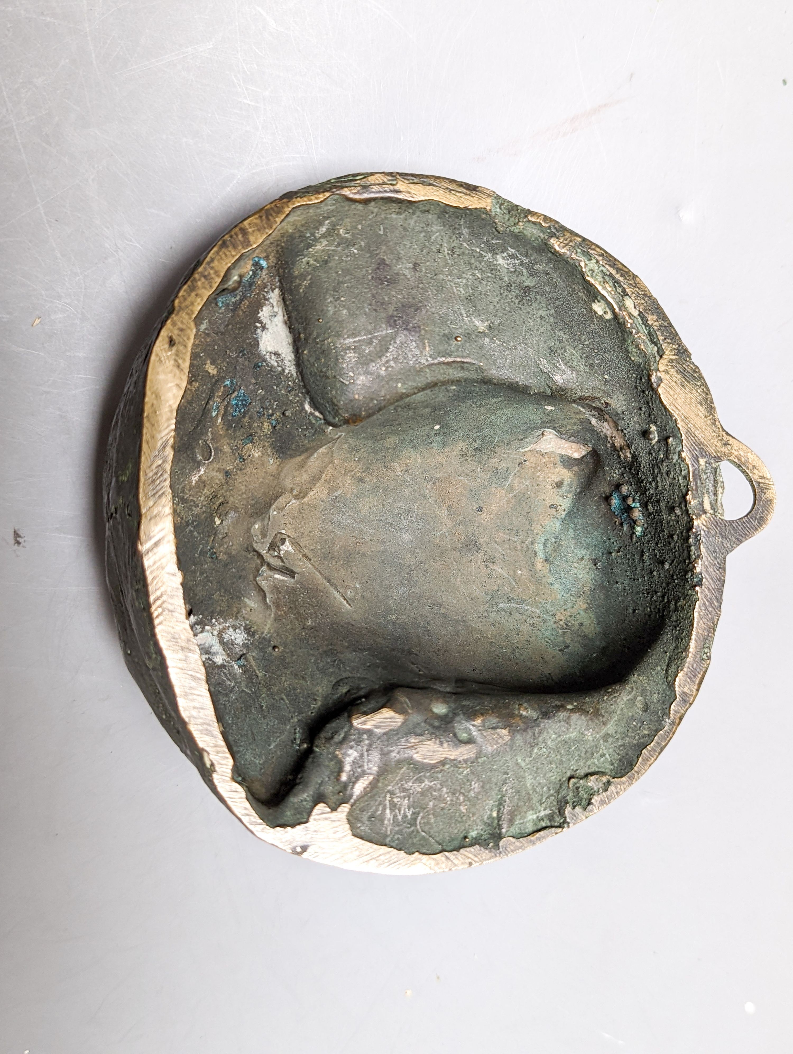 A bronze ram's head and a bronze relief